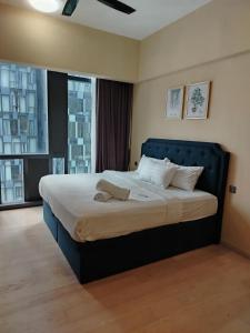 a bed with a blue headboard in a bedroom at KLCC by Star Residences in Kuala Lumpur