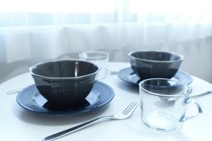 two black cups and plates and a glass on a table at Fontaine Kamata by Tranova in Tokyo