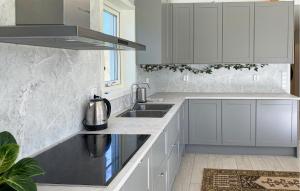 a kitchen with white cabinets and a sink at Gorgeous Home In Färjestaden in Färjestaden