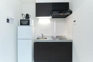 a small kitchen with a sink and a refrigerator at Fontaine Kamata by Tranova in Tokyo