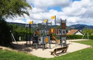 a playground in a park with a bench at Camping - Piscine - ccbbdag in Vic-sur-Cère