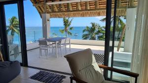 a dining room with a view of the ocean at La Mivoie Beachfront Penthouse in Rivière Noire
