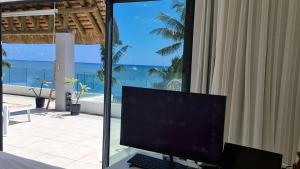 a computer monitor sitting on a desk in front of a window at La Mivoie Beachfront Penthouse in Rivière Noire