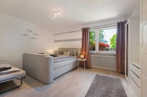 a living room with a couch and a window at Ferienwohnung Wilma Spetzerfehn in Großefehn 
