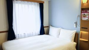 Postel nebo postele na pokoji v ubytování Toyoko Inn Nagoya-eki Shinkansen-guchi