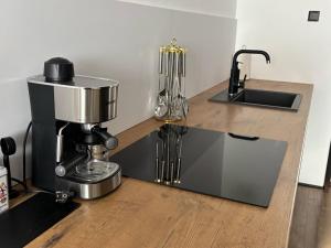 a kitchen counter with a coffee maker and a sink at Taki apartman in Debrecen