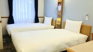 Postel nebo postele na pokoji v ubytování Toyoko Inn Nagoya-eki Shinkansen-guchi