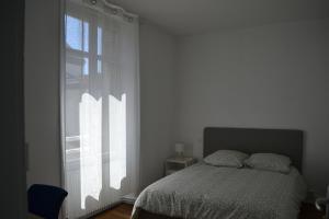 a bedroom with a bed and a large window at Maison de ville 4 chambres à Cholet, Idéale pour les familles, groupes et sportifs ! in Cholet