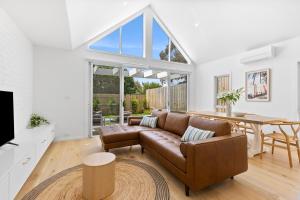 a living room with a couch and a table at Laguna Beach House Ocean Grove-pets welcome in Ocean Grove