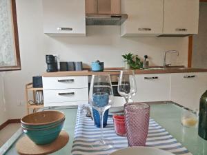 a kitchen with two wine glasses on a table at La Casina in Cecina