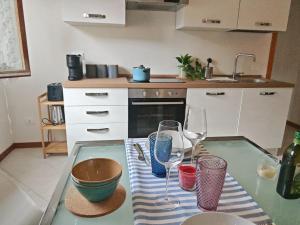 a kitchen with a glass table with two wine glasses at La Casina in Cecina