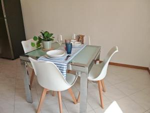 a dining room table with white chairs and a glass table at La Casina in Cecina +10 photos