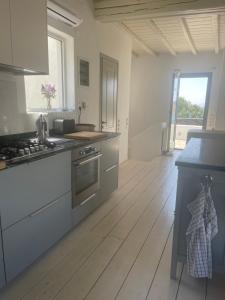 a kitchen with a wooden floor and a stove top oven at Villa Sandros Vourkari in Gialiskari