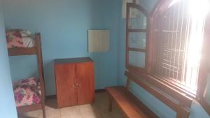 a bedroom with a wooden cabinet and a window at Hostel Iguazu Falls in Puerto Iguazú