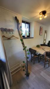 a room with a table and a tree painted on the wall at Cocoon Ny - DURBUY in Hotton