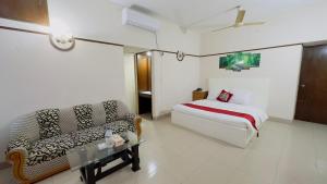 ダッカにあるHotel Dhaka City Innのベッドとソファのあるホテルの部屋