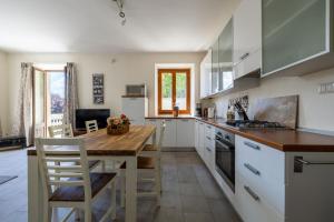 a kitchen with a wooden table and white cabinets at Apartment Katia - Menaggio in Menaggio +13 photos