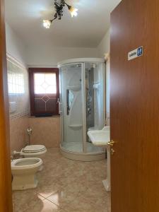 a bathroom with a shower and a toilet and a sink at Bed and Breakfast Victoria in Badolato Stazione