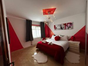 a red and white bedroom with a bed and a chandelier at Apartament zona 1 Decembrie in Tecuci