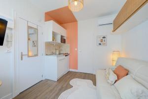 a living room with a couch and a kitchen at Urban - 800 m Gare- Hyper center - WiFi - Climatisé in Tours +6 photos