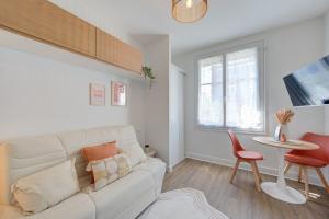 a living room with a white couch and a table at Urban - 800 m Gare- Hyper center - WiFi - Climatisé in Tours