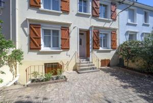a house with wooden windows and a brick driveway at Urban - 800 m Gare- Hyper center - WiFi - Climatisé in Tours