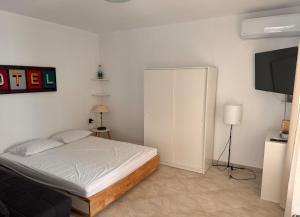 a bedroom with a bed and a flat screen tv at Iliada Suites Simousi Kythnos in Kithnos