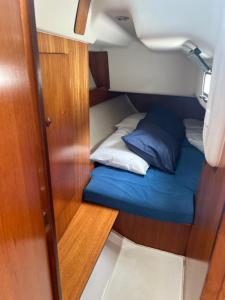 Una pequeña habitación con una cama y almohadas en un barco. en DeepBlue sail boat, en Lisboa
