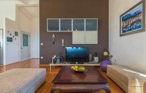 a living room with a television and a table with a bowl of fruit at Apartman Tara - Makarska by Villas Guide in Makar