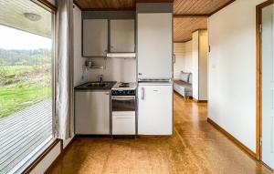 a kitchen with a refrigerator and a sink and a window at 2 Bedroom Amazing Home In Degeberga in Degeberga