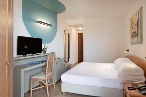 Ένα ή περισσότερα κρεβάτια σε δωμάτιο στο Rina Hotel