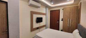 a hotel room with a bed and a tv on the wall at Tanwar Hotel & Restro in Khandela