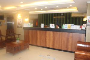 a bar in a restaurant with a woman behind the counter at Nest hotel - Bell Mansion in Manila