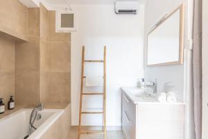 a bathroom with a tub and a sink and a ladder at Appartement spacieux, chaleureux & tout confort in Pertuis +15 photos