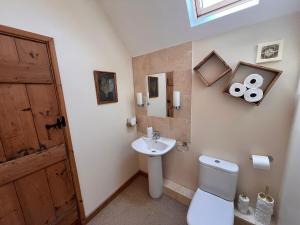 a bathroom with a white toilet and a sink at Barn Cottage in Binton +53 photos