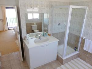 a bathroom with a white sink and a shower at Happy Wife in St. Helena Bay