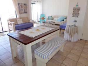 a living room with a table and a couch at Happy Wife in St. Helena Bay