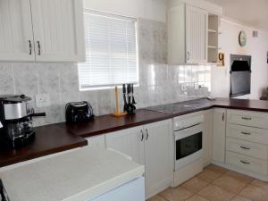 a kitchen with white cabinets and a counter top at Happy Wife in St. Helena Bay +19 photos