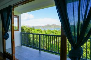 a room with a balcony with a view of the ocean at The Nest in Coron
