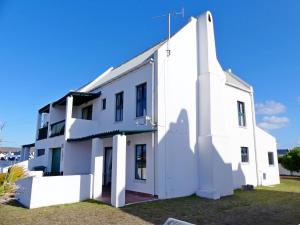 a white building with a blue sky in the background at Happy Wife in St. Helena Bay
