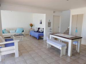 a living room with a table and a couch at Happy Wife in St. Helena Bay