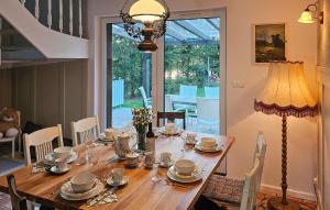 a dining room with a wooden table with a lamp at Beautiful Home In Podwilczyn With Sauna in Dębnica Kaszubska