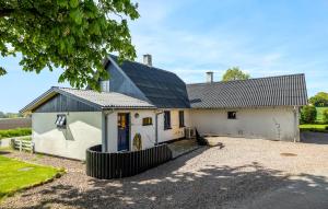 a white house with a black roof and a driveway at 3 Bedroom Cozy Home In Store Fuglede in Store Fuglede