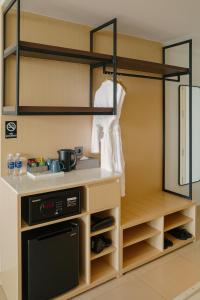 a kitchen with a counter with shelves and a dishwasher at Sea View Standard Room in The Arena Resort Cam Ranh in Cam Ranh International Airport
