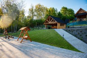 a park with a playground and a building with a house at Willa Krzyżówki obok Korbielowa in Krzyżówki