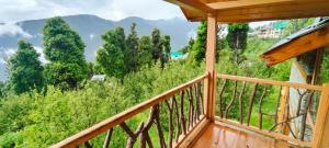 Elle comprend un balcon offrant une vue sur les arbres et les montagnes. dans l'établissement Shantchit Wellness Resort Hotel in Kasol Valley, à Kasol