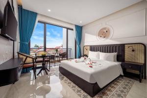une chambre d'hôtel avec un lit, un bureau et une table dans l'établissement ELC Boutique Hoi An Hotel, à Hội An