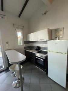 a kitchen with a white refrigerator and a table at White Shark Villas in Litochoro
