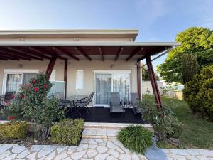 a house with a porch with a table and chairs at White Shark Villas in Litochoro