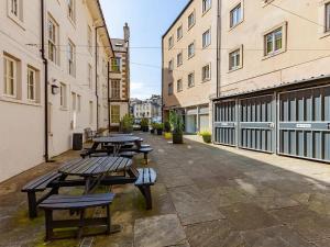 a row of picnic tables in a courtyard with buildings at For Student Only - Cable Street 10 Min Walk to Lancaster Station in Lancaster